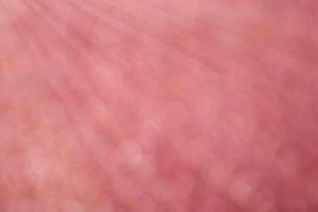 Red bokeh background with defocused round lights and sunbeams, flare overlayの写真素材