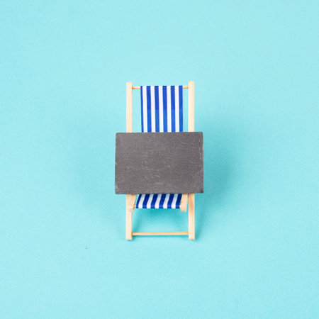 Lounge chair with a blank chalkboard sign, summer vacation travel by the seaの写真素材