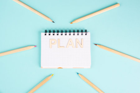 Plan is standing in a notebook, planning new goals, to do list, colorful pencils, new year...