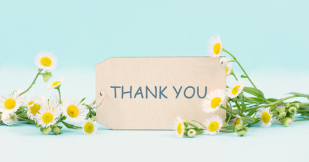 Thank you card surrounded by flowers, being thankful, support, help and charity concept, positive attitudeの写真素材