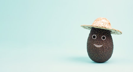 Avocado with a smiling happy face and a hat, vegan food, healthy diet, vegetarian lifestyleの写真素材