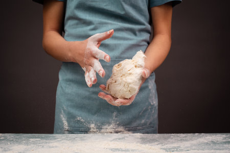 Baker kneading dough for pizza or artisan bread with his hands, preparing ingredients for food, baking pastryの写真素材