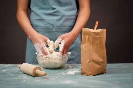 Baker kneading dough for artisan bread or pizza with his hands, prepare ingredients for food, baking...