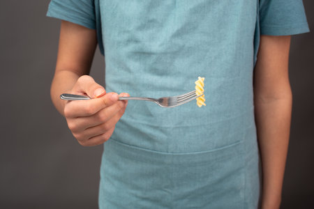 Cooked fusilli pasta on a fork, Italian food ingredients, preparing dinnerの写真素材