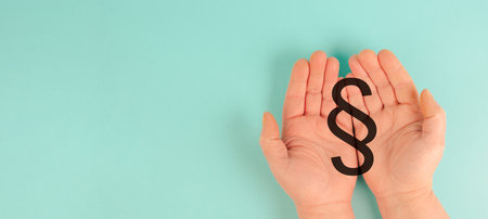 Paragraph sign in the hand, legal protection law right, justice and authority by court, regulation and copyrightの写真素材