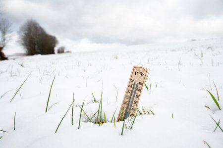 Thermometer in snow covered landscape, cold frosty weather forecast in winter, measure the...