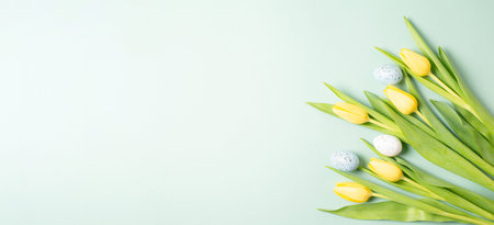 Colored easter eggs, yellow tulip flowers, spring season background