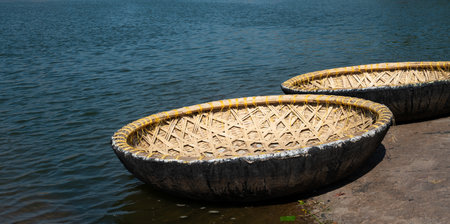 Coracle boats on the Tungabhadra River in Hampi, India, traditional round fishing basket boat made from cane, leather and bitumenの写真素材