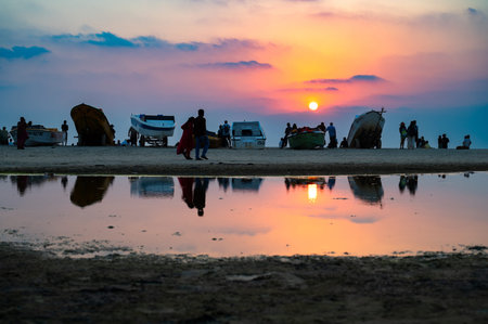 Sunset at Colva Goa beach in South India, silhouette of boats and people, tropical west coast, Arabian Sea in Asia, vacation destinationの写真素材
