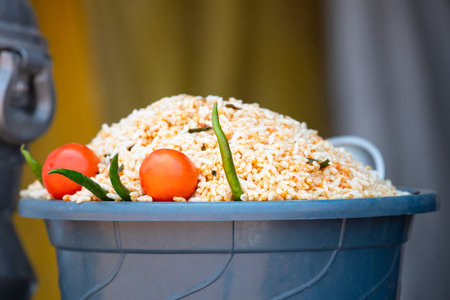 Rice and millet with tomato, green pepper chilli in a bowl, Indian street food sale at market stall,...
