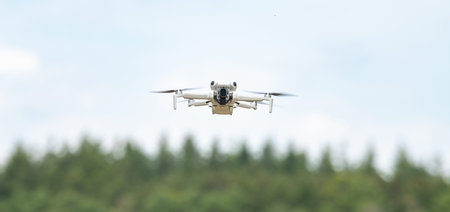 Flying drone in action, aerial copter, digital camera, modern technology used for photography,...