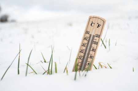 Thermometer in snow covered landscape, cold frosty weather forecast in winter, measure the...