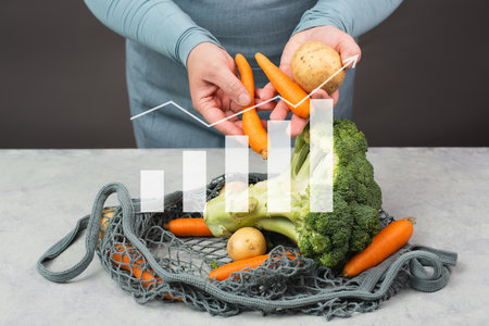 Grocery shopping, buying fresh vegetables, increasing food prices, high expensive living costs and inflation, broccoli, carrots and potatoes in a netの写真素材