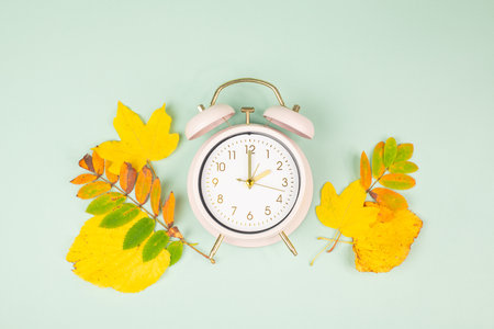 Winter time changeover, end of daylight saving time in autumn, alarm clock fall back switch, colorful foliage, change seasonの写真素材