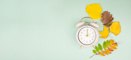 Autumn time change, end of daylight saving time, alarm clock fall back switch, colorful foliage, winter seasonの写真素材