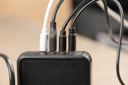 USB adapter overloaded with charge cables plugged into power strip, extension power outlet socket with plugsの写真素材