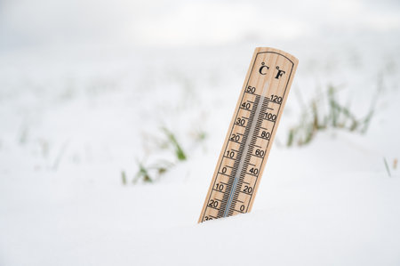 Cold frosty winter temperature, thermometer in snow covered landscape, weather forecast, measure climate changeの写真素材