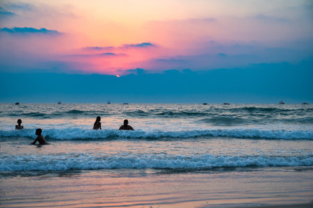 Sunset at Colva Goa beach in South India, silhouette of people swimming in Arabian Sea, tropical west coast, Asia, vacation destination, March 8th 2025のeditorial素材