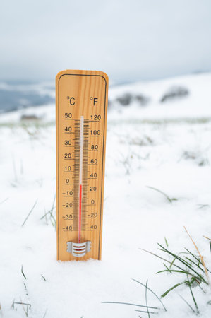 Thermometer in snow covered landscape, cold frosty weather forecast in winter, measure the...