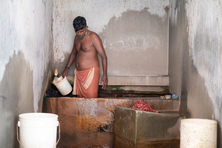 Dhobi Ghat, open air laundry in Kochi, India, man washing pile of dirty clothes, large concrete wash...