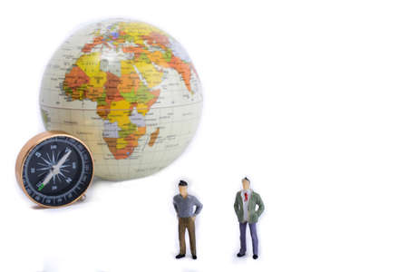 A couple by the side of a globe with a compass on isolated white backgroundの写真素材