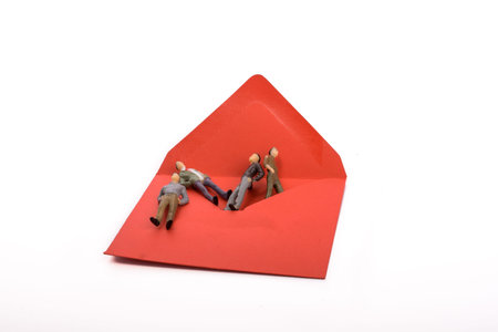 Figurine men out of an envelope on white background