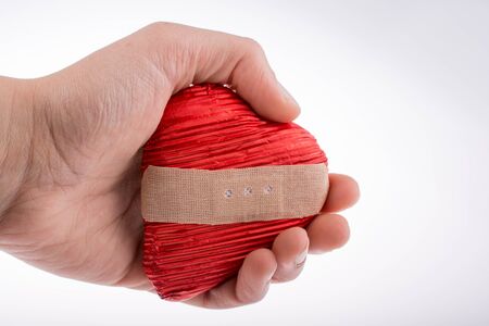 Heart shaped object in plaster in handの写真素材