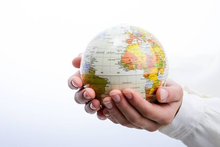 Child holding a small globe in hand on white backgroundの写真素材