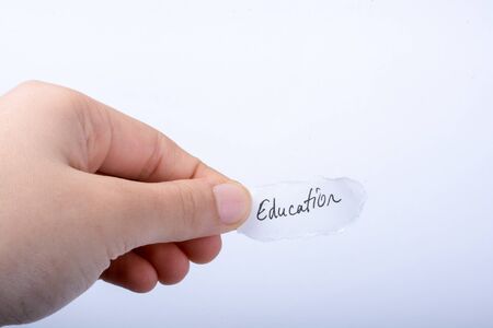 Child hand holding  a  education written a piece of torn paperの写真素材
