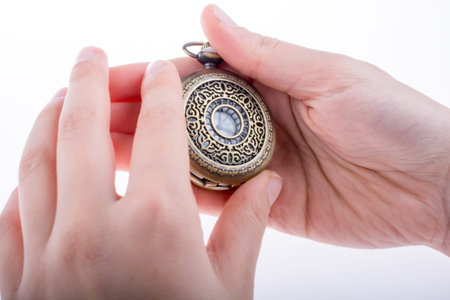 Hand holding a retro styled pocket watch in hand
