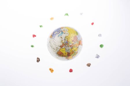 globe orbit and crumpled papers on a white backgroundの写真素材