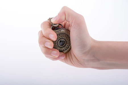 Hand holding a retro styled pocket watch in hand