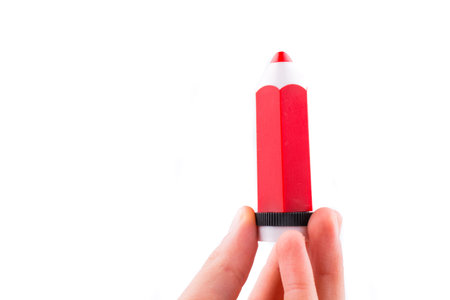 Hand holding a red model pencil in hand on white backgroundの写真素材