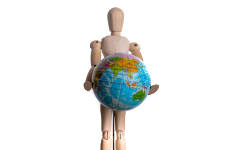 Wooden man holding a globe on a white backgroundの写真素材