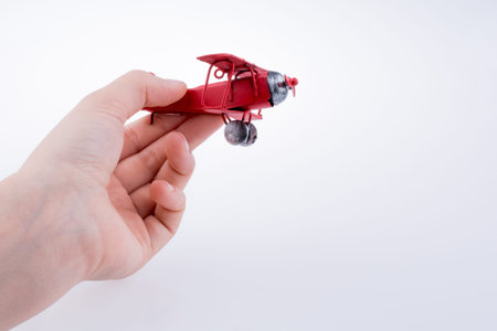 Hand holding a red Plane on a white background