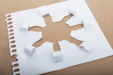 Sun shape made through torn paper in white backgroundの写真素材