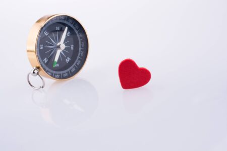 Compass near a Red heart on a white backgroundの写真素材