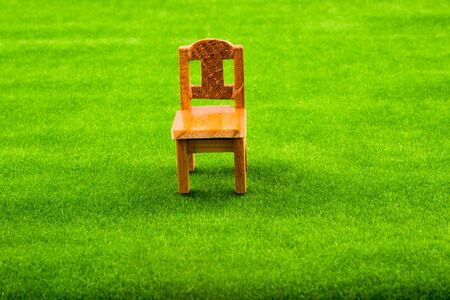 Little model wooden chair on green fake grassの写真素材