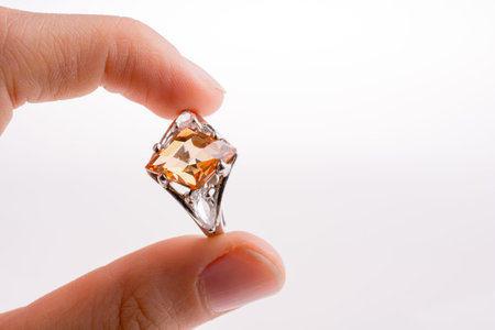 Hand holding a ring on a white background