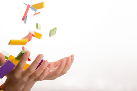 Falling colorful domino onto a  hand