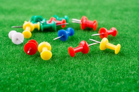 Colorful pins on green grassの写真素材