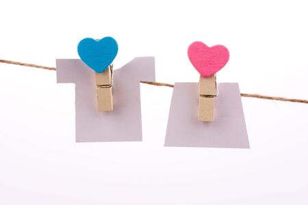 Hearted clothespins hanging on a thin ropeの写真素材