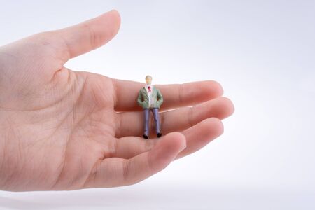 Hand holding a human figure on a white backgroundの写真素材