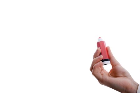 Isolated thick, red pencil in hand on a white backgroundの写真素材