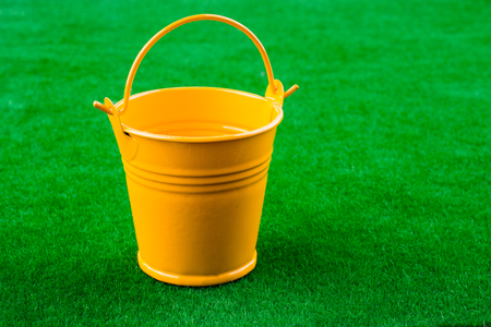 Littlegift box with a ribbon placed on green grassの写真素材