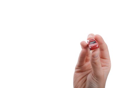 Child's hand holding a red car on a white backgroundの写真素材