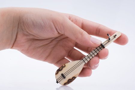 Hand holding turkish musical instrument saz on a white background