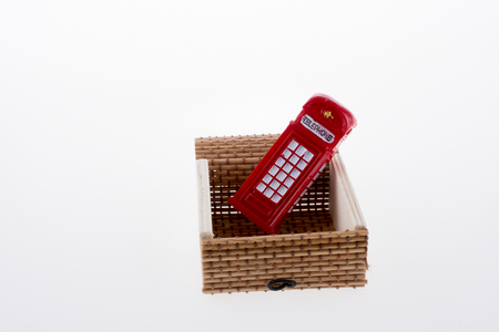 Isolated telephone booth in a straw box on white backgroundの写真素材