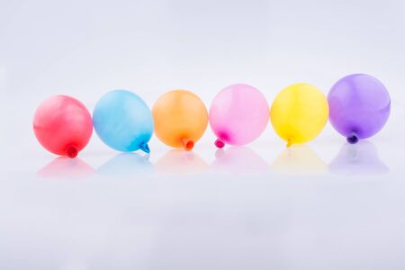 Colorful small balloons in line on a white backgroundの写真素材