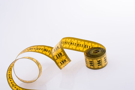 Yellow color measuring tape on a white background
